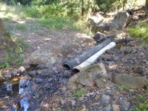 Exposed drains across a rocky creek