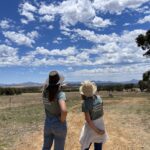 Two women pointing and admiring the view of the Stirling Ranges from the the planting site.