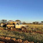 White ute and tractor on paddock