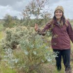 Woman holding the stem of a small tree