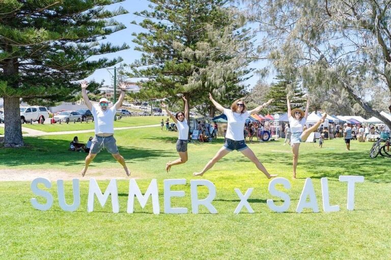 Four people jumping in the air in front of a sign reading "Summer x Salt"
