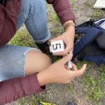 Person drawing number onto plastic plot marker