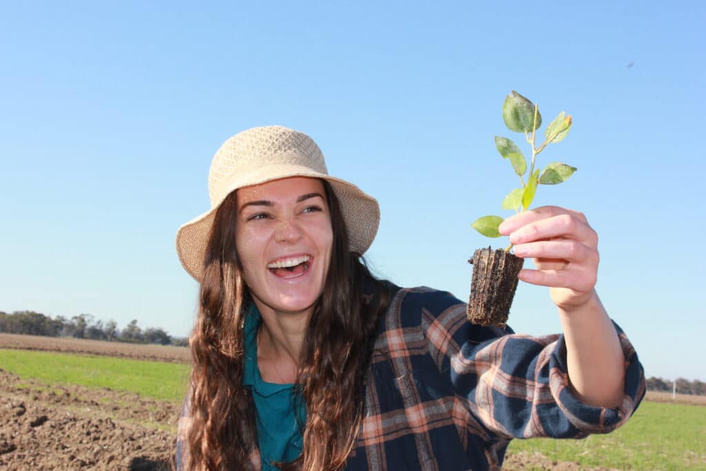 Woman holding seedling at tree planting event