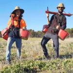 Two men posing with planting buckets and devices.