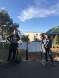 Two women standing next to two signs