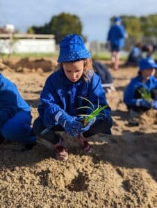 Girl crouching holding a seedling