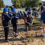 school student standing around planting area