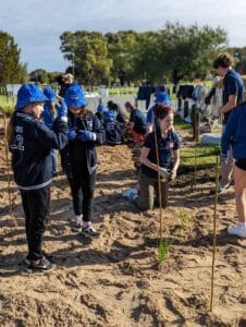 school student standing around planting area