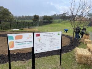 Two signs in front of planting area