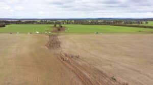 Aerial view of an open paddock with ripped planting lines