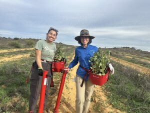 Two women with Pottiputkis and seedling buckets.