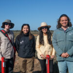 The team standing in front of the planting rows.