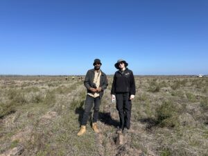 Man and woman with cameras standing in between the planting rows.
